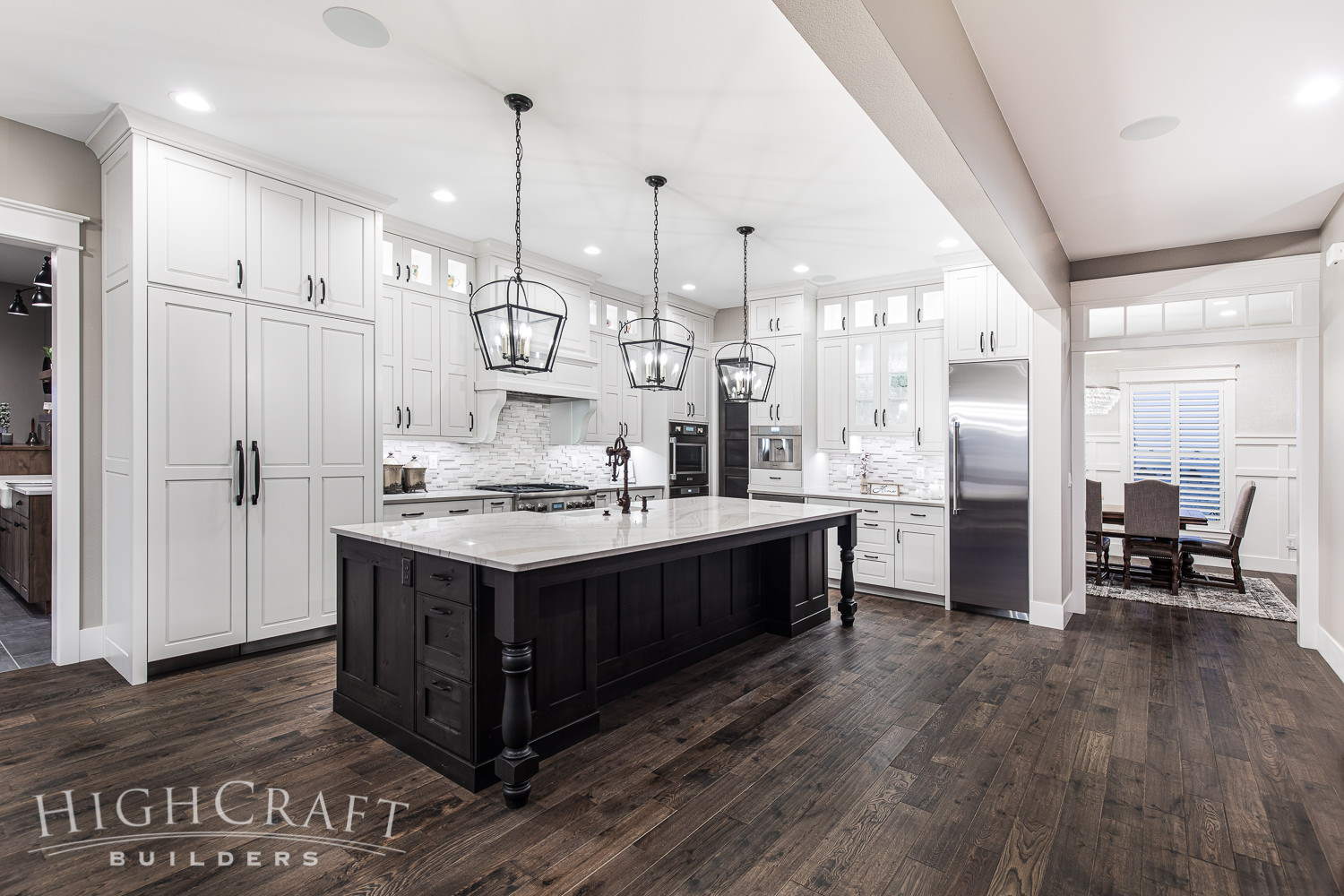 custom_home_builder_colorado_white_farmhouse_kitchen_large_dark_stained_island_view_to_dining