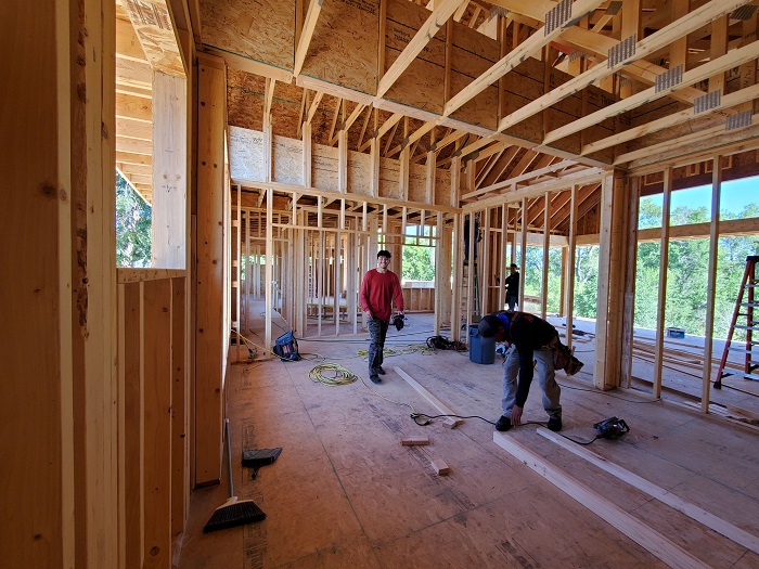 custom_home_building_fort_collins_co_second_floor_framing_smiling_contractor
