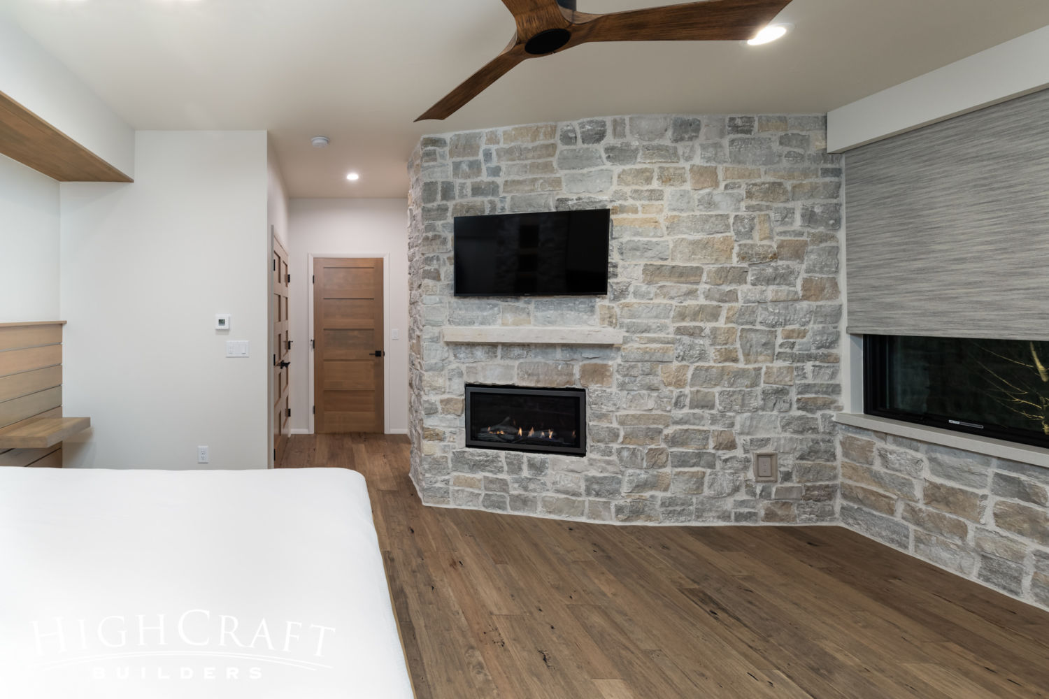 contemporary-custom-home-builder-guest-bedroom-stone-accent-wall-fireplace