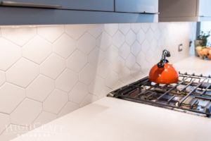 highcraft modern kitchen orange tea kettle-white-hex-tile-backsplash