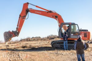 colorado-custom-home-builder-client-groundbreaking-orange-excavator