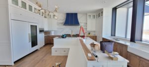 kitchen-remodel-navy-blue-gas-range-hood-white-cabinets-in-progress