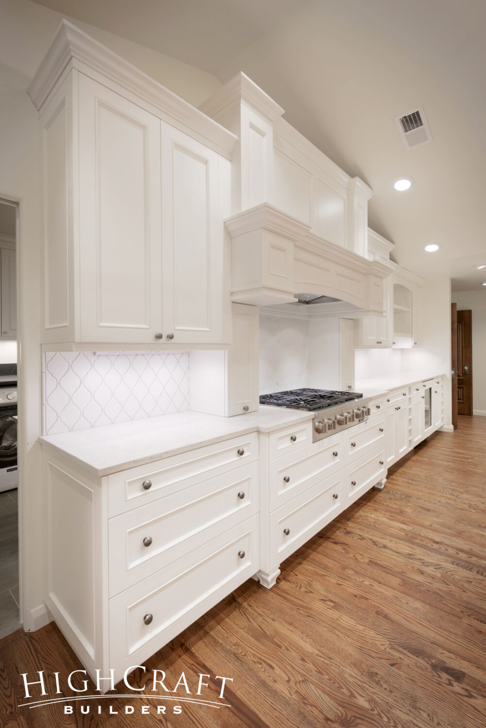 Kitchen-And-Great-Room-Addition-White-Cabinets-Range-Hood-Furniture-Leg-Quartz-Countertops-Arabesque-Tile
