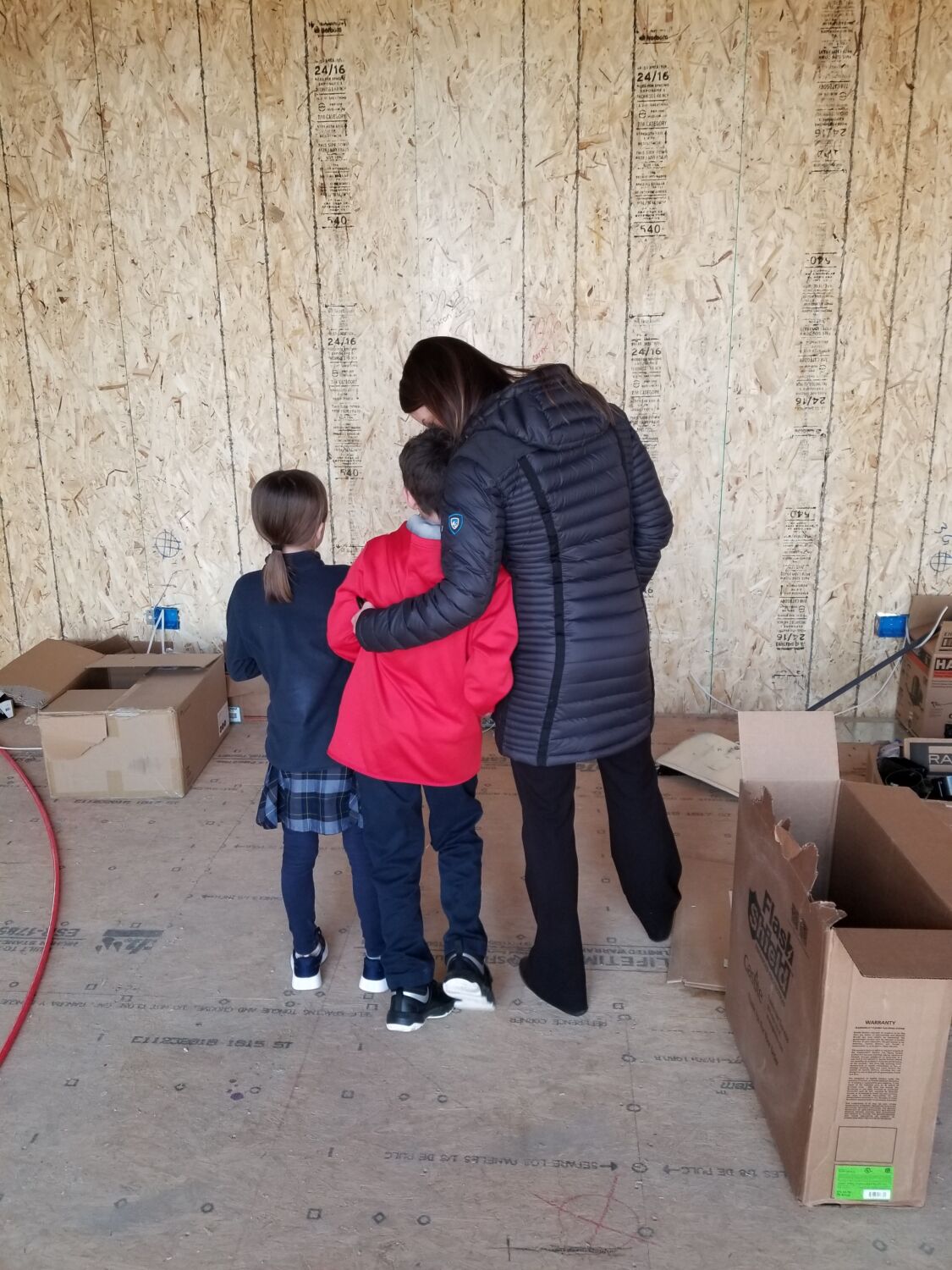 loveland-home-builder-clients-writing-on-walls-hugging